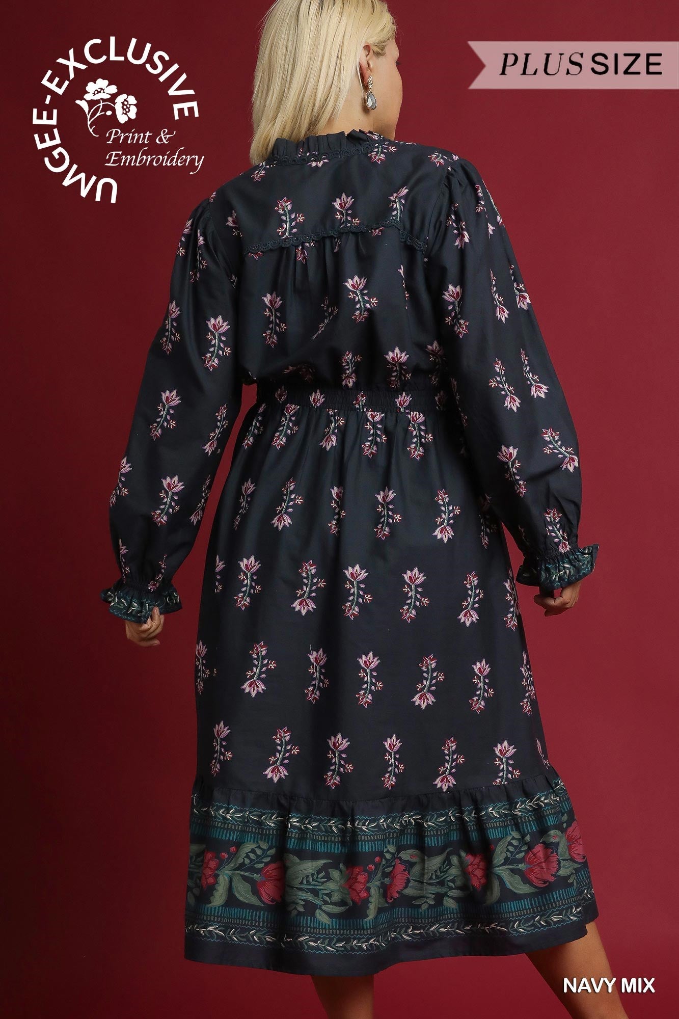 Woman wearing a navy floral dress with a red background and branding text.