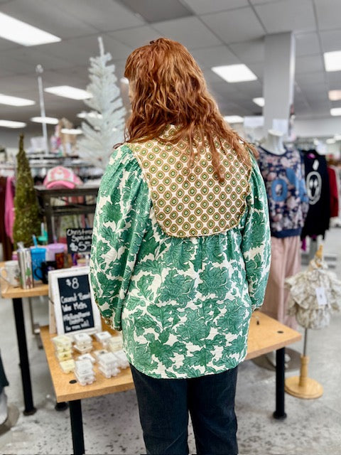 Person wearing a green floral patterned shirt in a store setting