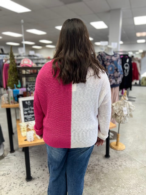 Person wearing a pink and white sweater in a store setting