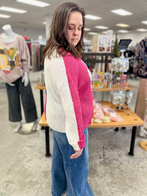 Woman wearing a pink and white sweater in a store setting