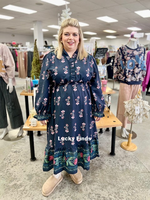 Woman wearing a floral dress in a store with 'Lucky Finds' branding.