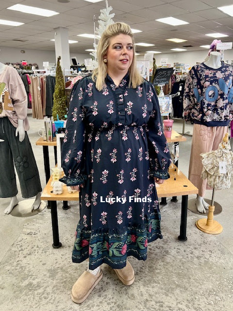 Woman wearing a floral dress in a store with 'Lucky Finds' branding.